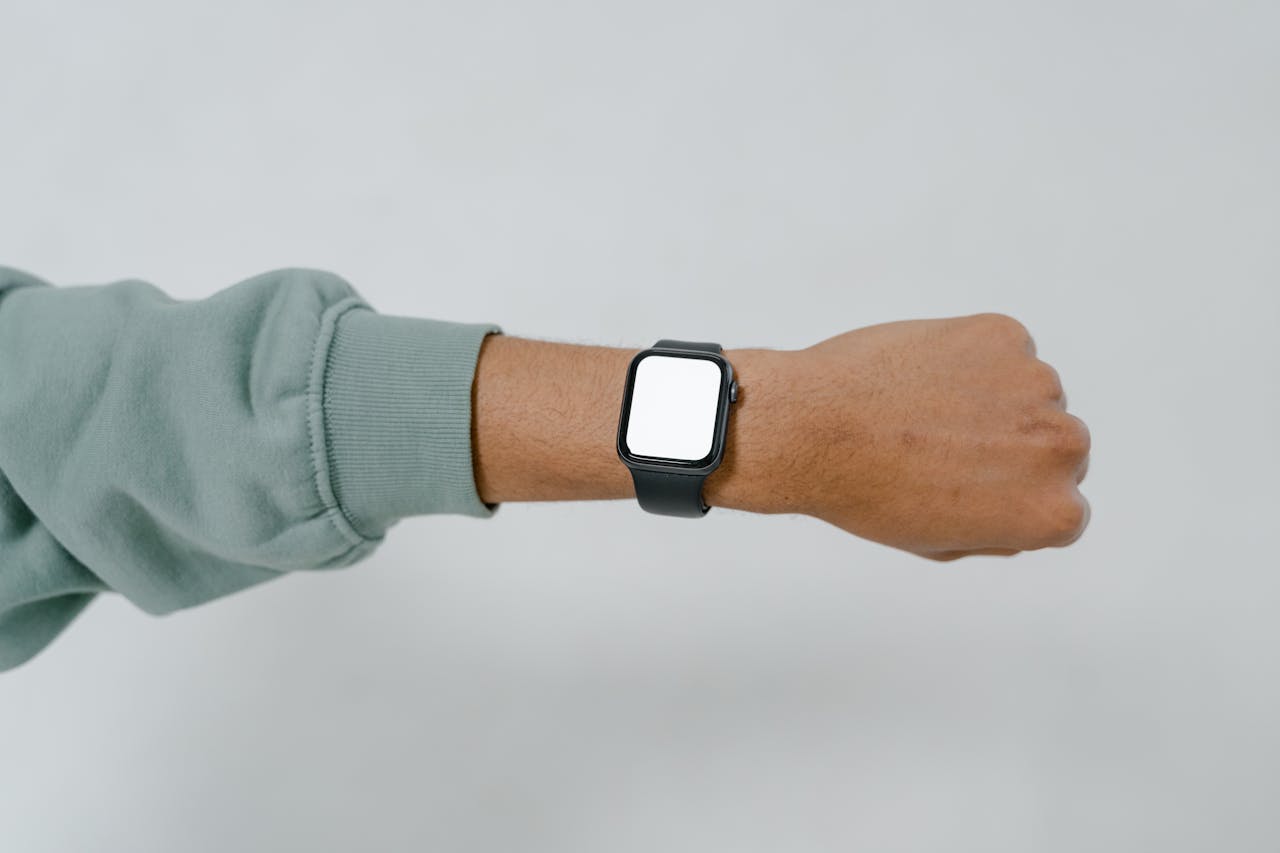 A close-up view of a smartwatch with blank screen on an adult's wrist, ideal for mockup designs.